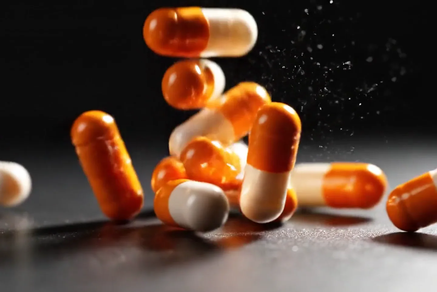 Capsules falling on a dark ground